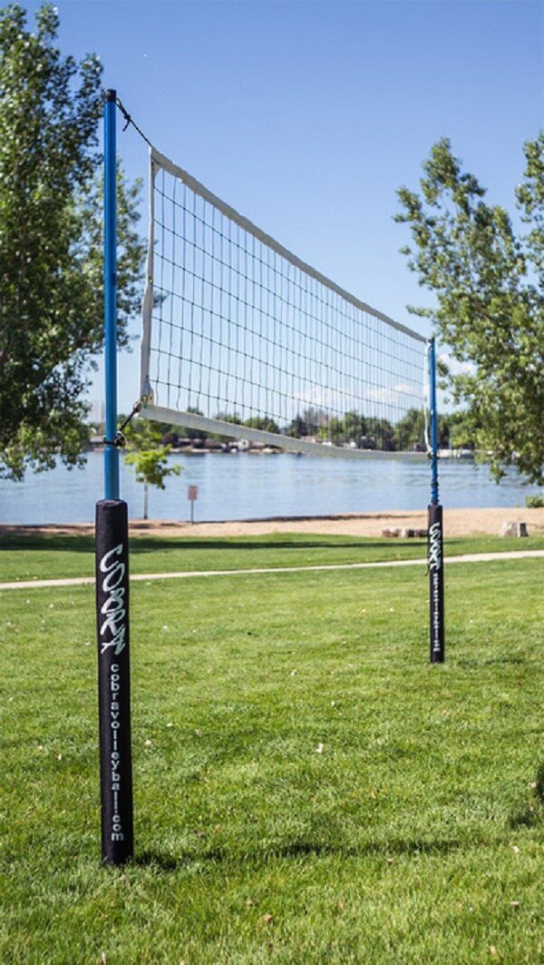 A volleyball net in the middle of a park.