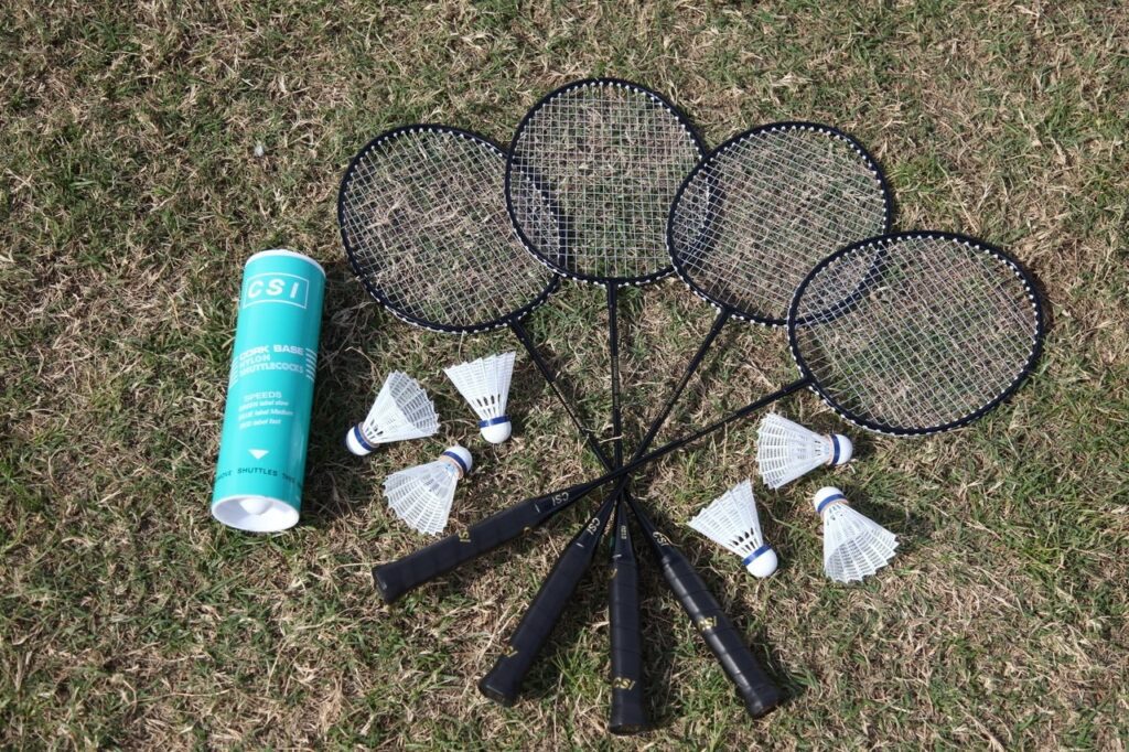 A group of badminton rackets and some shuttlecocks.