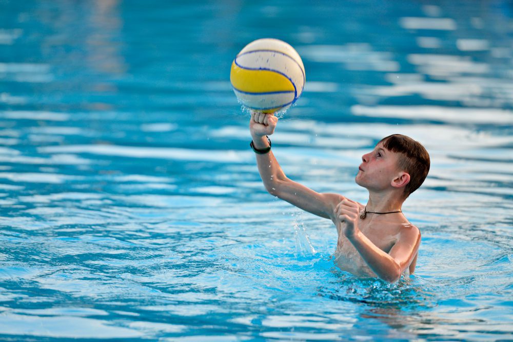 A boy in the water with a ball