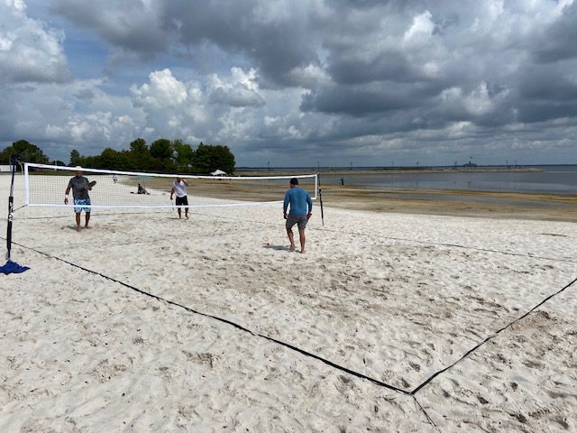 A group of people playing volleyball on the beach.