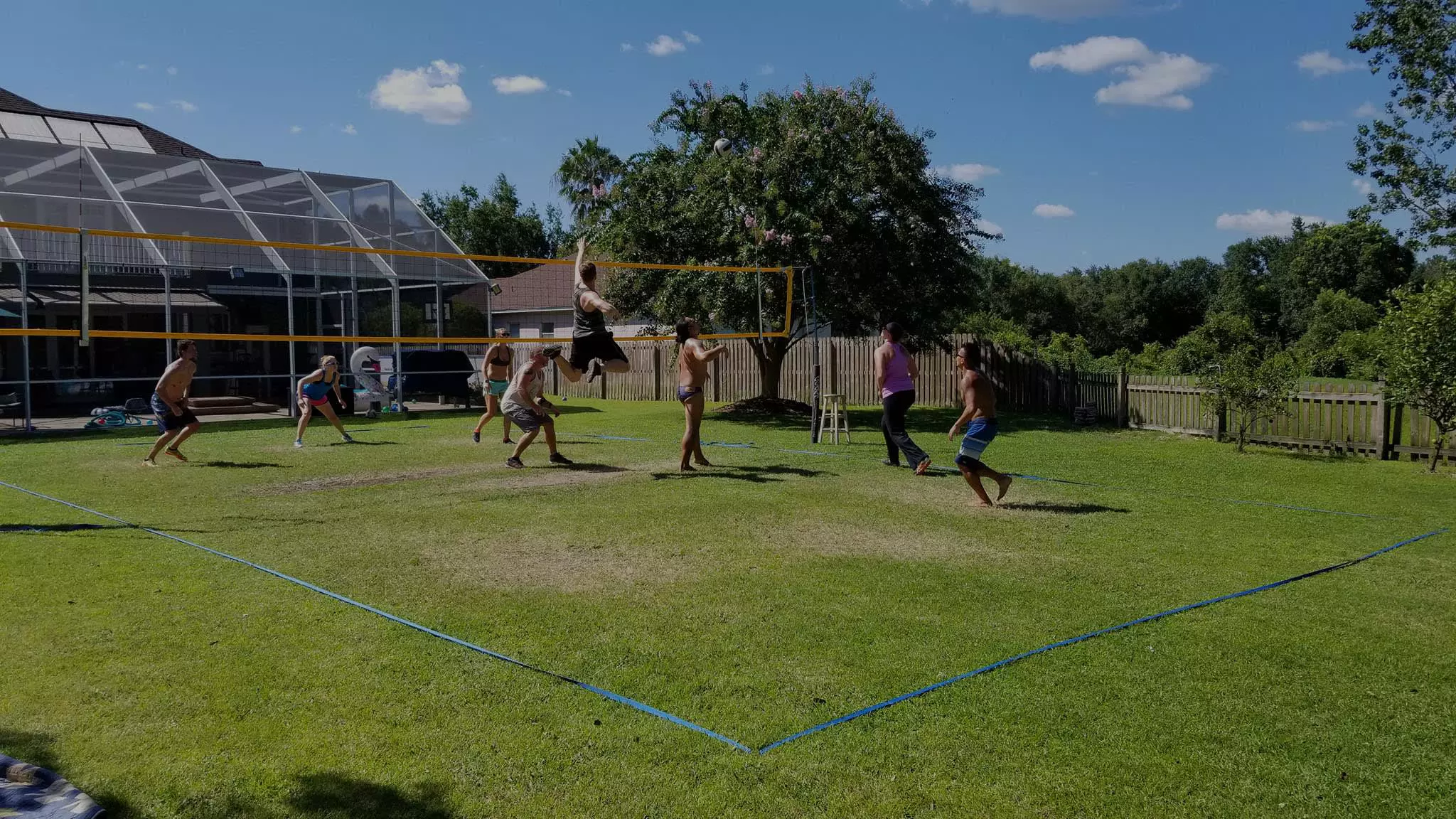 people playing volleyball in a garden