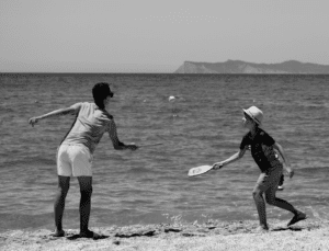  Two people playing tennis at the beach